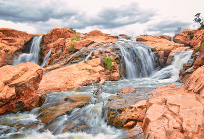 Scenic view of waterfall against sky