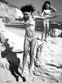 Full length portrait of shirtless woman standing on land
