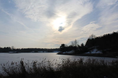 Scenic view of lake against cloudy sky