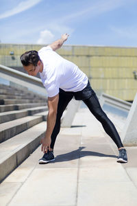 Confident young man exercising during sunny day