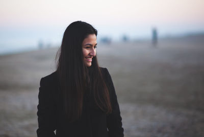 Portrait of a young woman at the beach with winter clothing. lifestyle photography.