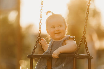 Close-up of boy swinging at playground