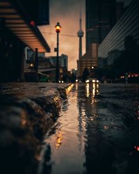 Reflection of buildings in puddle on street