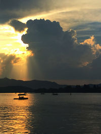 Boat in sea against cloudy sky