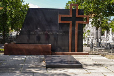 View of cross in cemetery against building