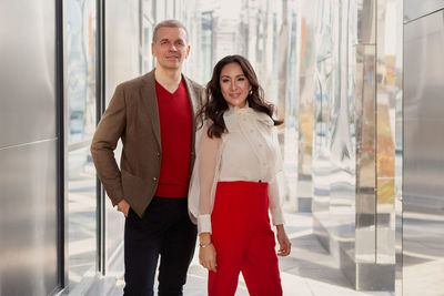 Fashion style clothes, business casual. businessman wearing brown jacket  and woman in red pants
