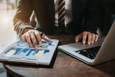 Midsection of businessman working at desk in office