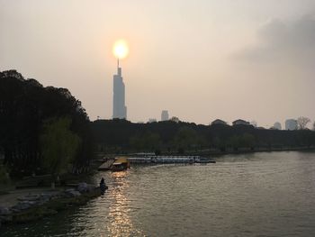 Scenic view of illuminated city against sky during sunset