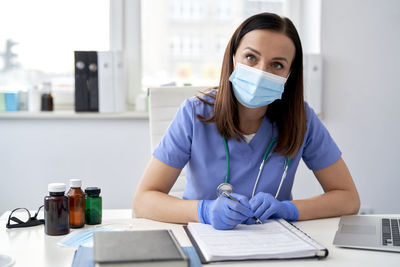 Portrait of young woman working at table