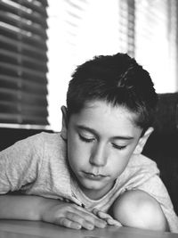 Close-up portrait of young boy  sitting at home