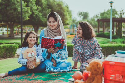 Rear view of a smiling girl sitting outdoors