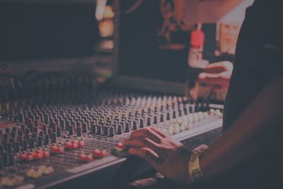 Midsection of man mixing sound in recording studio