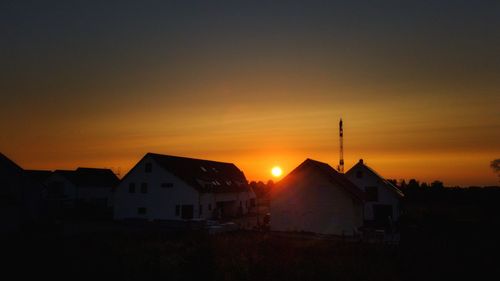 Silhouette buildings against sky during sunset