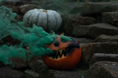 Close-up of pumpkin against stone wall during halloween