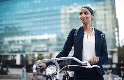 Smiling businesswoman with bicycle