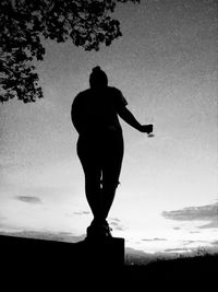 Low angle view of silhouette man standing against sky