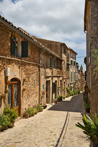 Footpath amidst buildings against sky