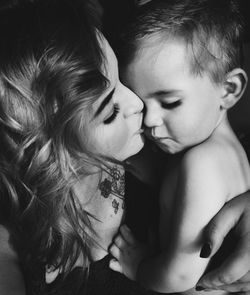 Close-up of mother with baby on bed