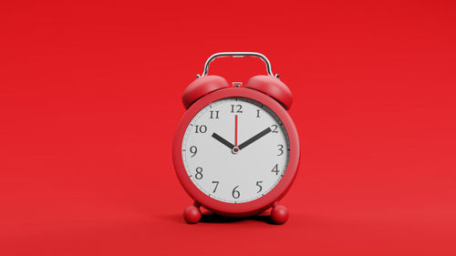 Close-up of clock against red background