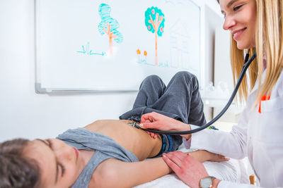 Female doctor examining boy at clinic