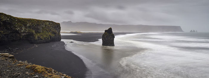 Scenic view of rocks in sea against sky