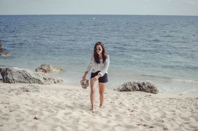 Full length of young woman walking at beach