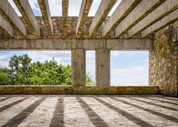 View of wall and trees against sky