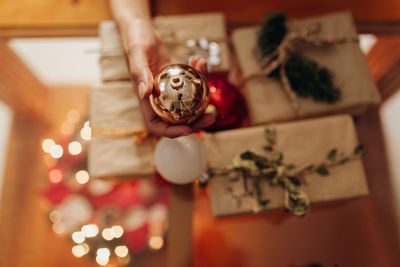 Cropped hand of woman holding christmas decoration home