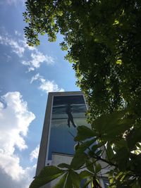 Low angle view of bird perching on statue against sky