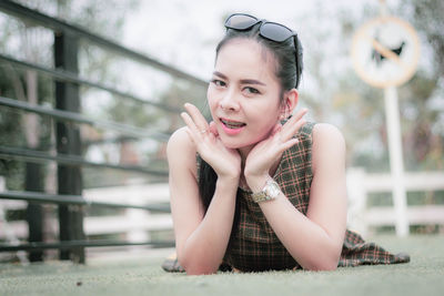 Portrait of smiling woman lying at footbridge 