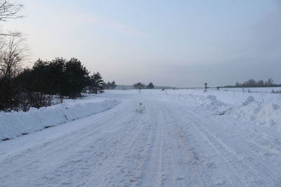 Scenic view of snow covered field against sky