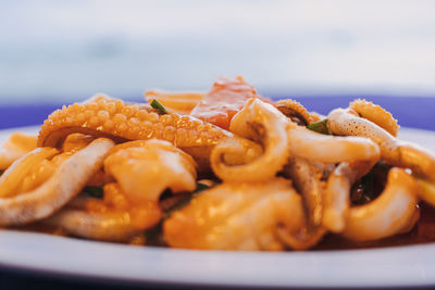 Close-up of pasta with fries in plate