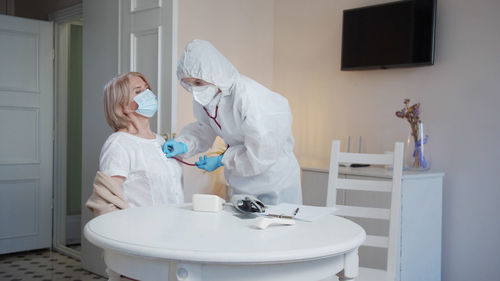 Portrait of doctor examining patient during pandemic