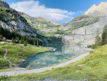 Scenic view of lake by mountains against sky