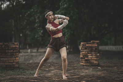 Full length of woman standing against trees