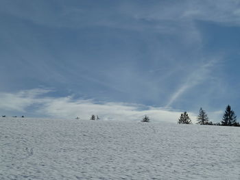 Scenic view of snow covered land against sky