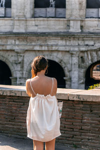 Rear view of woman standing against building