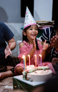 Portrait of young woman holding lit candles