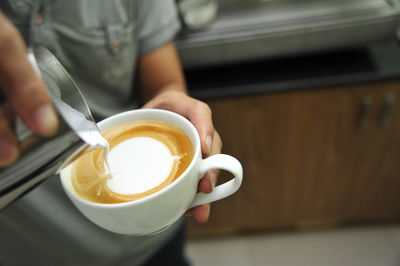 Midsection of woman holding coffee cup