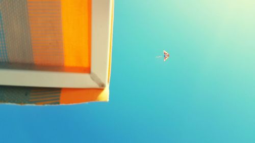 Low angle view of airplane against clear blue sky