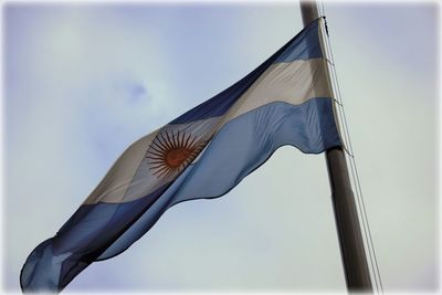 Low angle view of flags against sky