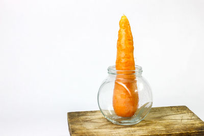 Close-up of glass jar on table against white background