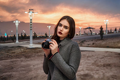 Portrait of young woman photographing