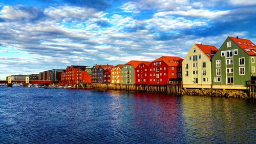 Houses by sea against sky