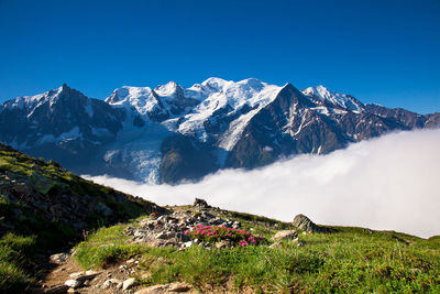 Scenic view of snowcapped mountains against blue sky