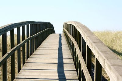 Footbridge against clear sky