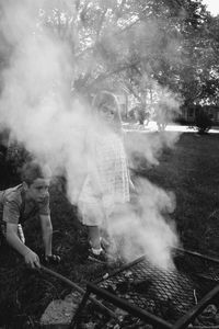 Rear view of people standing on barbecue grill