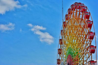 Low angle view of ferris wheel against blue sky