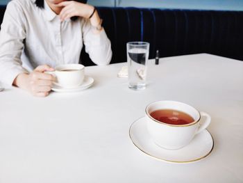 Midsection of coffee cup on table