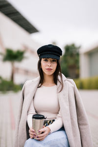 Portrait of young woman drinking coffee